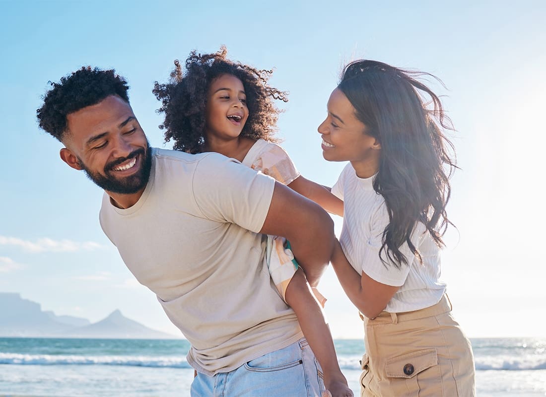 Personal Insurance - Cropped Shot of an Affectionate Young Family of Three Taking a Walk on the Beach